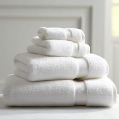 a stack of white towels sitting on top of a table