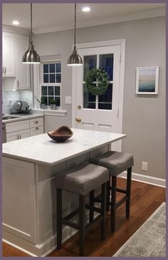 a kitchen island with two stools in front of it