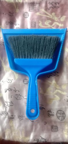 a blue brush sitting on top of a bed