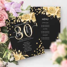 two black and gold wedding menus with flowers on the table next to each other