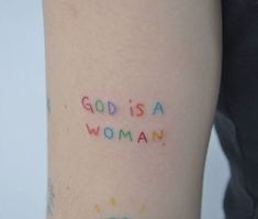 a woman's arm with the words god is a woman written on it