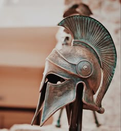 a close up of a bronze helmet on a pole