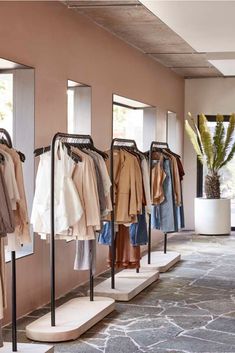 a row of clothing racks with clothes hanging on them