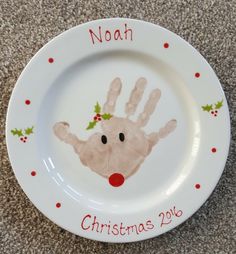 a white plate with a handprinted christmas ornament on it and the words noah