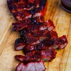 sliced bacon on a cutting board next to a bowl of ketchup and sauce