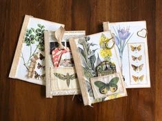 four small pieces of fabric with butterflies and flowers on them sitting on top of a wooden table