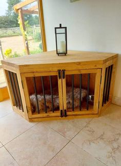 a dog in a cage on the floor next to a window with a candle inside