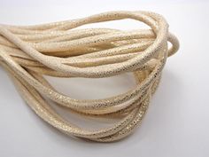 a close up of a white cord with gold glitters on it's ends