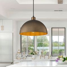 a kitchen with white cabinets and an island in front of two large windows that look out onto the backyard