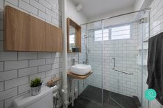 a bathroom with a sink, toilet and shower stall in the corner next to a window