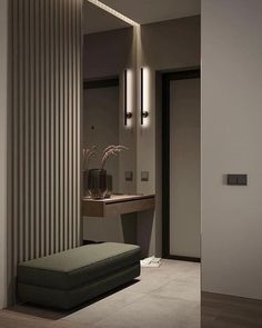 a bathroom with a bench, mirror and lights on the wall next to each other