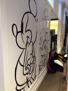 the wall is decorated with black and white cartoon characters on it's walls, along with other decorations