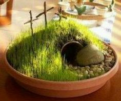 a potted plant sitting on top of a wooden table next to a cross in the grass