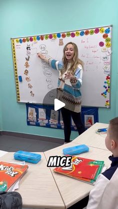 a woman standing in front of a white board