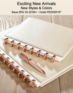 two notebooks and pen sitting on top of each other with text stating new arrivals