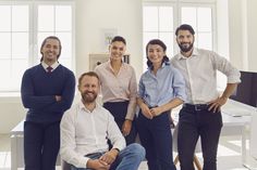 a group of people standing and sitting next to each other