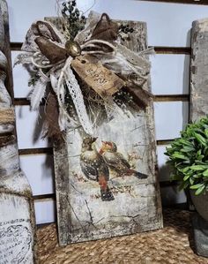 a wooden sign with a bird on it next to a potted plant