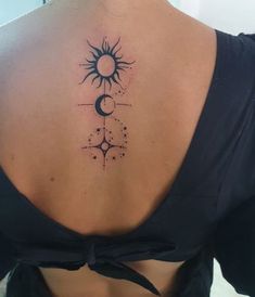 the back of a woman's neck with a sun and moon tattoo on it