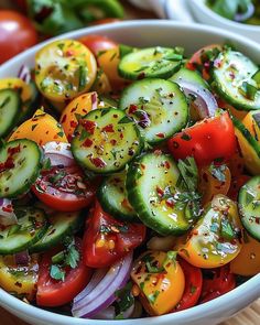 a white bowl filled with cucumbers, tomatoes and other veggies on top of a wooden table