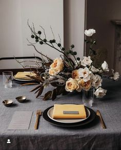 the table is set with flowers and silverware