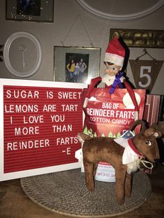 an elf is sitting on top of a stuffed animal next to a sign that says sugar is sweet lemons are tart i love you more than reindeer ears