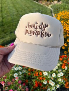 Add a touch of Southern sweetness to your style with our embroidered hat featuring the word 'howdy pumpkin' embroidered with a western script.  This classic sand-beige colored trucker cap is perfect for anyone who loves Southern charm and effortless style with colors ready for fall! Whether you're heading to a pumpkin patch, a day out with friends, or simply want to express your playful side, this hat is a must-have accessory. Details: Colors Available: Sand (Beige), Material: Polyester Foam Fro Country Style Baseball Cap, Country Style Snapback Hat With Curved Brim, Country Style Snapback Hat, Country Style Trucker Hat For Country Events, Fun Adjustable Trucker Hat For Country Events, Adjustable Fun Trucker Hat For Country Events, Country Style Adjustable Snapback Hat, Fun Trucker Hat For Country Events One Size, Trendy Trucker Hat For Country Events