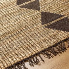 a brown and black rug on top of a wooden floor