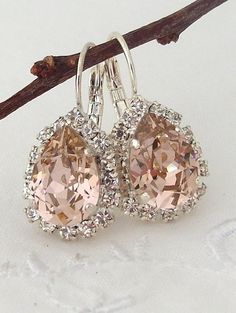 two pairs of earrings are hanging from a branch