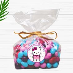 the hello kitty candy bag is filled with colorful candies and has a bow on it