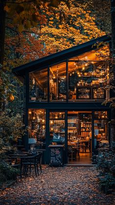 the outside of a restaurant with tables and chairs in front of it, surrounded by trees