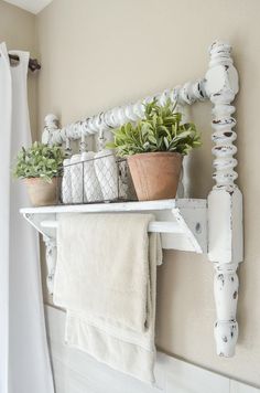 a white shelf with some plants and towels on it