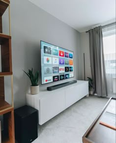 a flat screen tv sitting on top of a white entertainment center in a living room