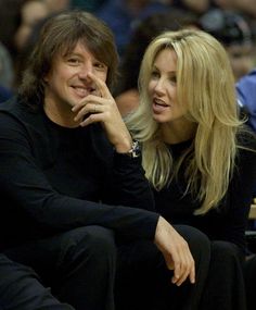 a man and woman sitting next to each other at a basketball game