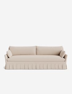 a white couch with pleated cushions on it's back and armrests