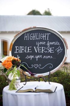 a table with a sign and flowers on it that says, highlight your favorite bible verse