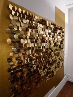 the wall is covered with many different types of wood discs and has a white door in front of it