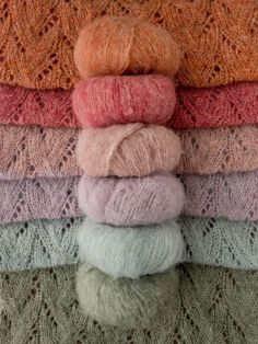 several skeins of yarn are stacked on top of each other in different colors