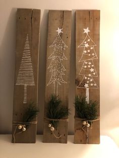 three wooden planks decorated with christmas trees and pine cones, tied with twine