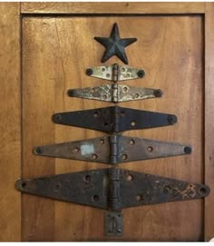 a metal christmas tree on top of a wooden door with an iron star hanging from it's side