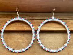 Say hello to these big beautiful white Christmas themed hoops! Hand beaded with premium white, red, green, and blue Miyuki delica glass seed beads stitched with premium Miyuki nylon threads onto a stainless steel bezel circle. Attached to a pair of sterling silver fish hook ear wires. Large, lightweight and hypoallergenic. White Christmas Theme, Christmas Beading, Beaded Earring, Silver Fish, Bead Stitching, Earring Ideas, Beaded Hoops, Christmas Earrings, Seed Bead Earrings