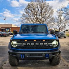 the front end of a blue truck parked in a parking lot