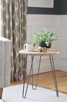 a small table with a potted plant sitting on top of it next to a couch