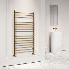 a white bathroom with a gold towel rack