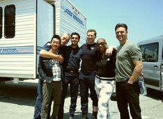 a group of people standing next to each other in front of a camper trailer