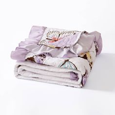 three folded blankets sitting on top of each other in front of a white background,