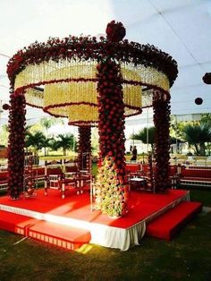 an outdoor ceremony setup with flowers on the stage