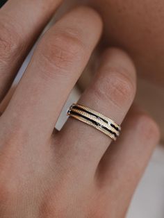 a woman's hand with two gold rings on her left and one in the middle