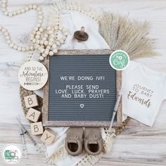 a baby announcement is displayed on a table with other items including shoes and t - shirts