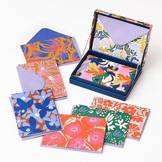 four colorful cards in a box on a white surface