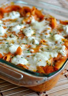 a casserole dish with tomatoes, cheese and parmesan sauce on top